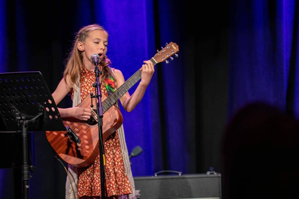 Girl with guitar playing on stage (1)